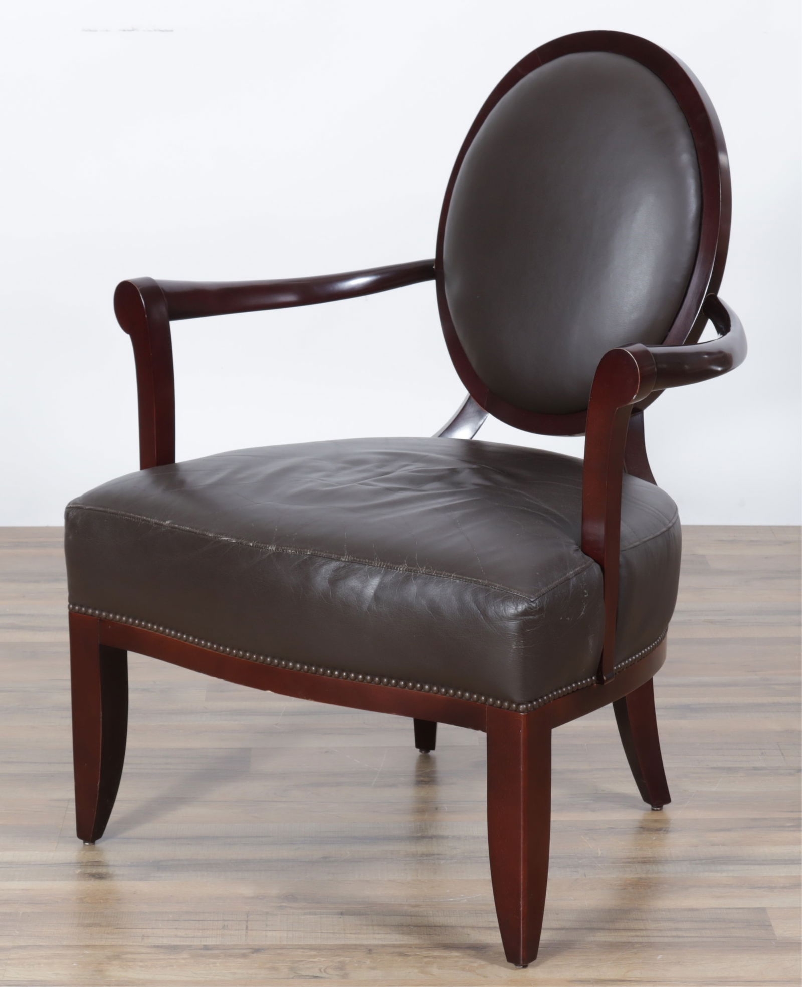 Barbara Barry Baker Oval Back Armchair: Barbara Barry Baker Oval-Back Armchair, back with X-frame, dark brown upholstery with brass tack trim. Dimensions: 37 1/2" H x 29 1/2" W x 29"D 
