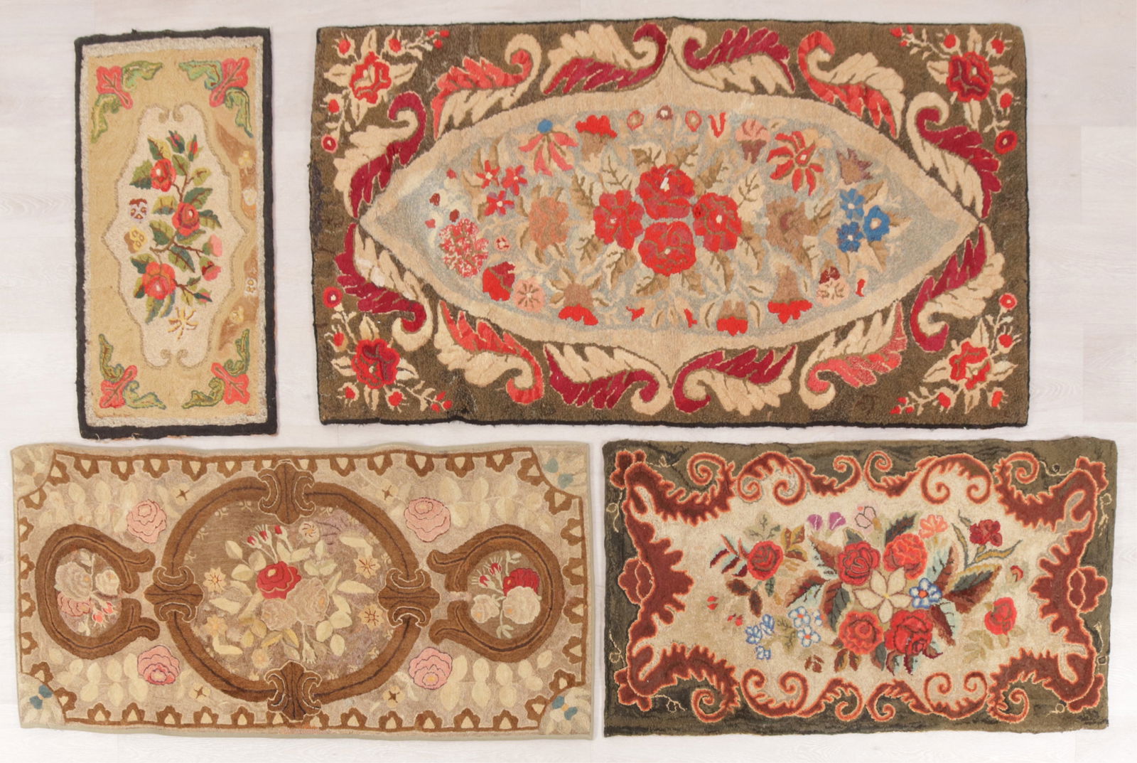 4 Floral Patterned Hook Rugs: Group of 4 floral patterned American hook rugs, fields with large center floral medallion, in greens, brown, red, violet, tan and off white colors, backed in fabric,one rug 2-2 x 4-10 machine made