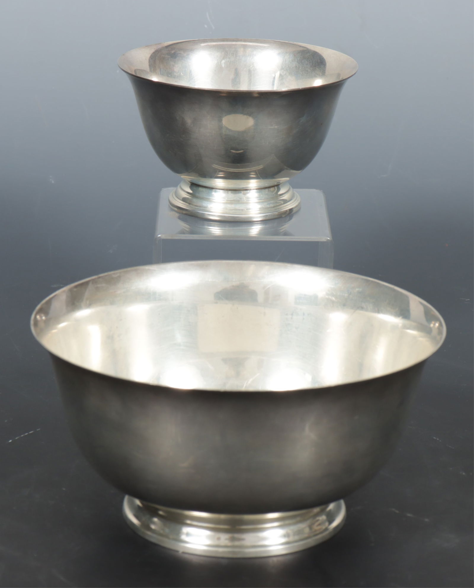 Two Sterling Silver Revere Bowls: Two American sterling silver Paul Revere reproduction bowls. Comprising: larger manufactured by Lunt and smaller manufactured by Stieff. 11.75 OZT. Dimensions: 3" H x 6" Diameter and 2.5" H x 4"