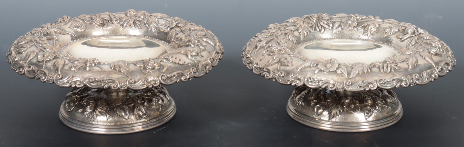 Pair A. Jacobi & Co Sterling Silver Repousse Bowls: A pair of A. Jacobi & Co, Baltimore, antique sterling silver floral and foliage repousse pedestal bowls, late 19th century. 27.48 OZT. Dimensions: 3.25" H x 7.75" diameter 