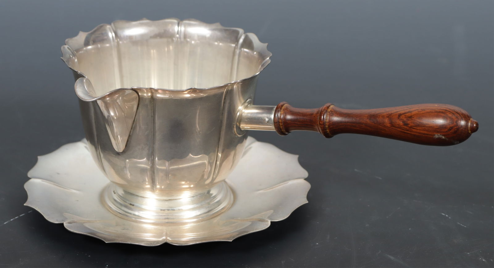 Cartier Sterling Silver Pipkin & Saucer: Cartier, sterling silver pipkin with wooden handle and matching saucer, 'Early Dublin Design', pattern 743-D. Gross weight of 5.27 OZT. Dimensions: 3" H x 6" D. 