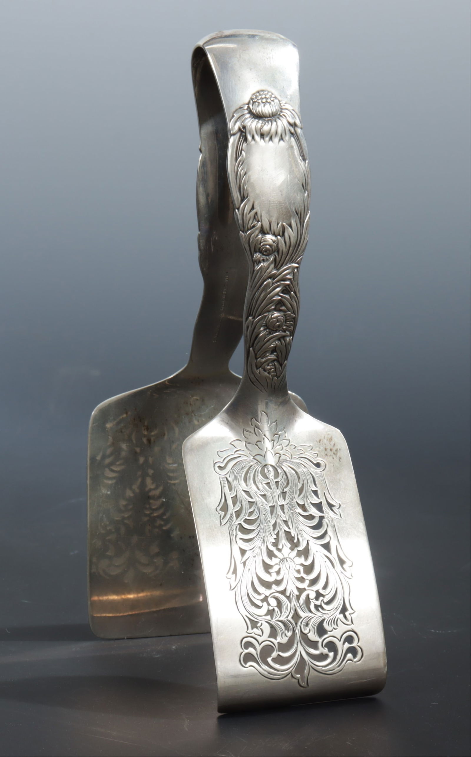 Tiffany & Co Sterling Silver Asparagus Tongs: Antique Tiffany & Co sterling silver Chrysanthemum patter asparagus tongs, 1892-1902 T date mark. Stamped T / Tiffany & Co / Sterling / Pat. 1880. 6.14 OZT. Dimensions: 7.75" long 