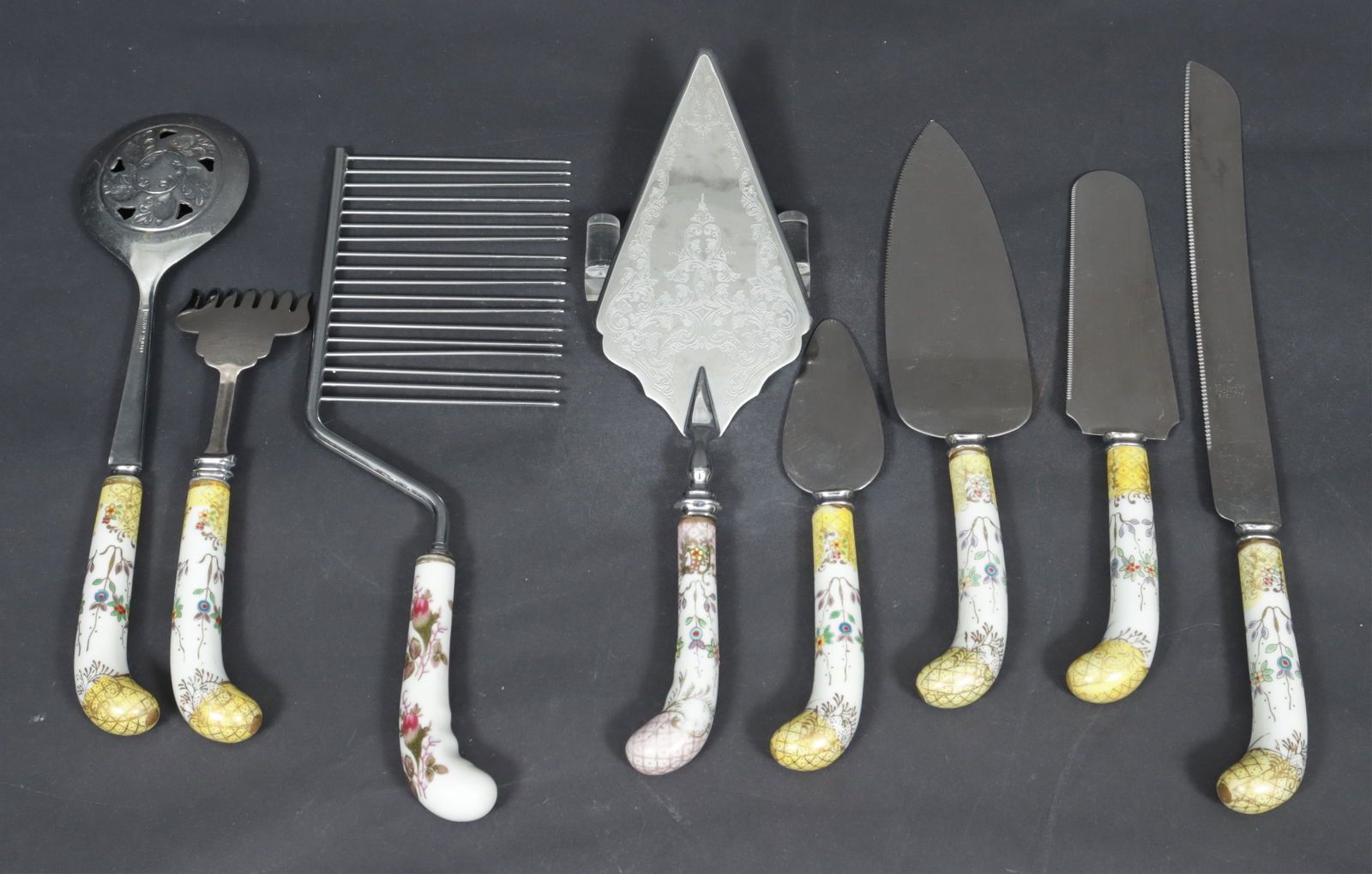 Vintage Sheffield House of Prill Serving Utensils: Vintage Sheffield and House of Prill porcelain handled serving utensils. Comprising: bread knife, cake/pie knife, spoon, fork, cheese server. Together with a bread fork and pie server. Dimensions: Lar