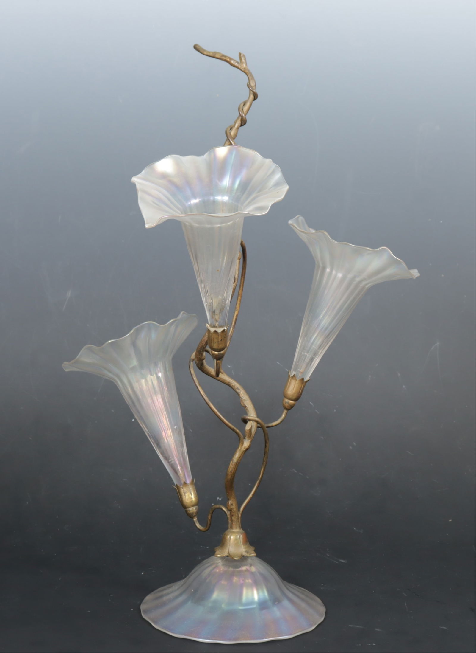 John Walsh Walsh - Metal and Glass Epergne: John Walsh Walsh, British, 1850-1951, Iridescent glass and metal epergne, 3 trumpet flower vases, naturalistic gilt metal branch and tendril on a domed glass base, c. 1905, metal marked along top of b