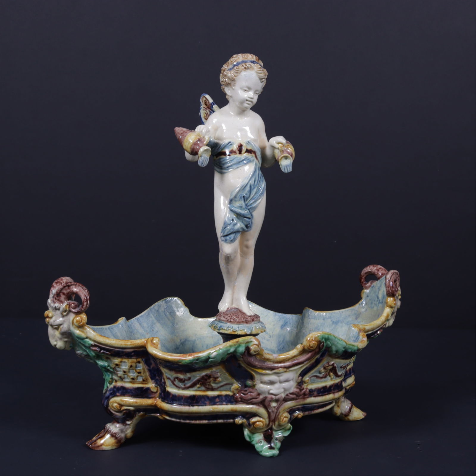 Manner of Thomas Victor Sergent Centerpiece: 19th C. Manner of Thomas Victor Sergent (1830-1890) French barbotine centerpiece, Psyche/Eros, rams head handles and Neptune center medallion Dimensions: 14 1/2 x 14 1/2 Property from a Washington