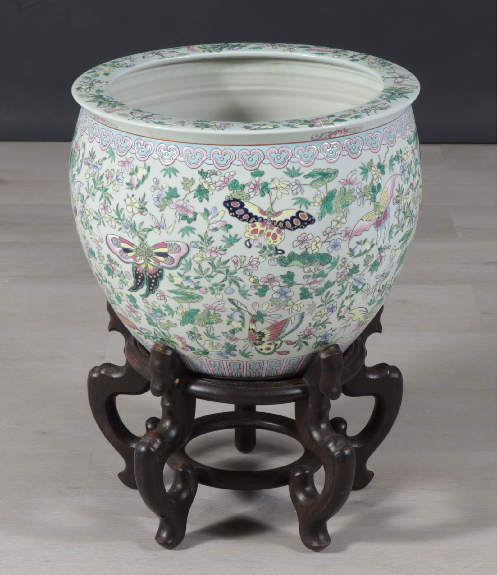Asian Celadon Porcelain Jardiniere on Stand: Asian porcelain jardiniere with incised and painted butterfly and foliage on pale porcelain ground with ebonized hardwood stand. Dimensions: 13.75" H x 16.75" Diameter. 23" H on stand.