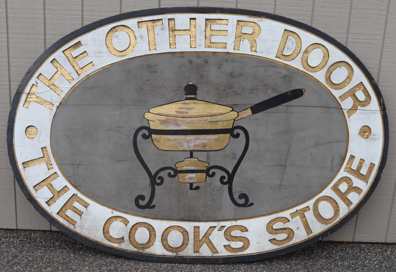The Cook's Store, Large Wooden Sign: A large outdoor painted wood sign reading "The Other Door / The Cook's Store" Dimensions: 54" H x 81" W x 1.50" D
