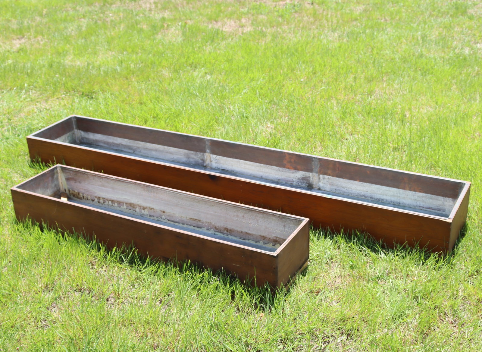 Two Copper Lined Pine Planters: Two rectangular copper line pinewood planters. Dimensions: Larger 6.5" H x 73.25" W x 12.5" D