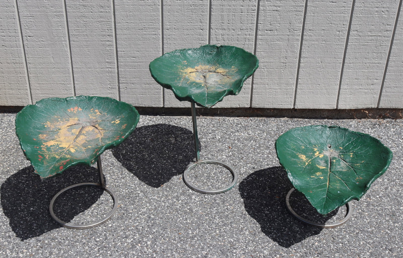 Cast Cement Leaf Form Tables: A grouping of three green painted cast cement leaf form accents, currently being used as table tops on metal bases. Dimensions: Largest 19" H x 16" W x 19" L