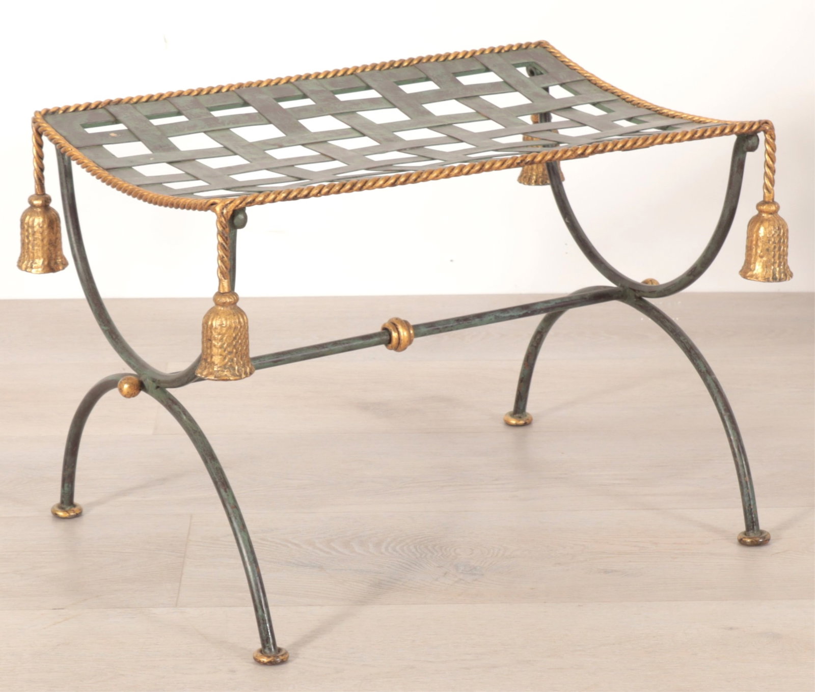 Classical Style Curule Bench: A classical style patinated bronze and gilt-metal curule leg bench. Bronze frame and woven seat with applied gilt-metal tassel detail. Dimensions: 15" H x 20.75" W x 14.5" D