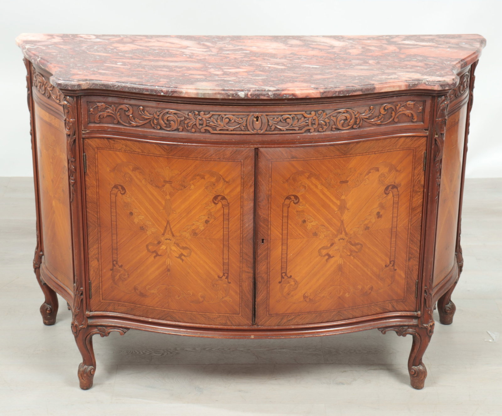 Louis XV Style Marquetry Inlaid Satinwood Cabinet: Louis XV Style Marquetry Inlaid Satinwood Cabinet. Red marble top, carved frieze drawer over double doors enclosing three drawers. Dimensions: 36.5" H x 53.5" W x 22.25" D Property from a Bronxville