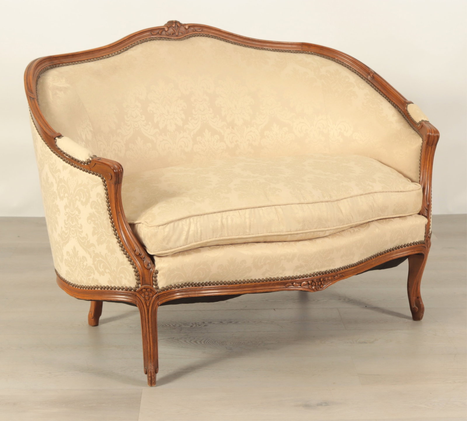 Louis XV Style Canape: French Provincial Louis XV style walnut stained canape, serpentine shape floral wood carved crest, cabriole legs, passed elbow rests, damask pattern fabric, nail head trim, down filled cushion Dimensi