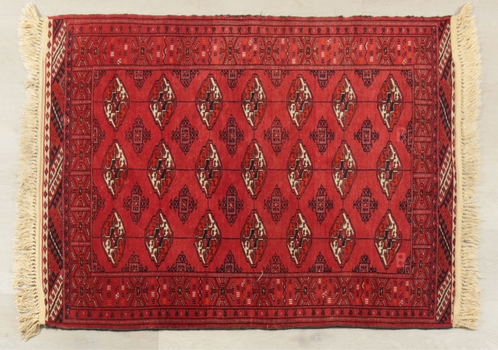Turkmen Bokhara Wool Rug 3-3 x 4-4: Turkmen Bokhara wool rug, fine hand knotting, red ground color throughout with black and white tekke style guls, original fringe to one end with later fringe added Dimensions: 3-3 x 4-4 Property from 