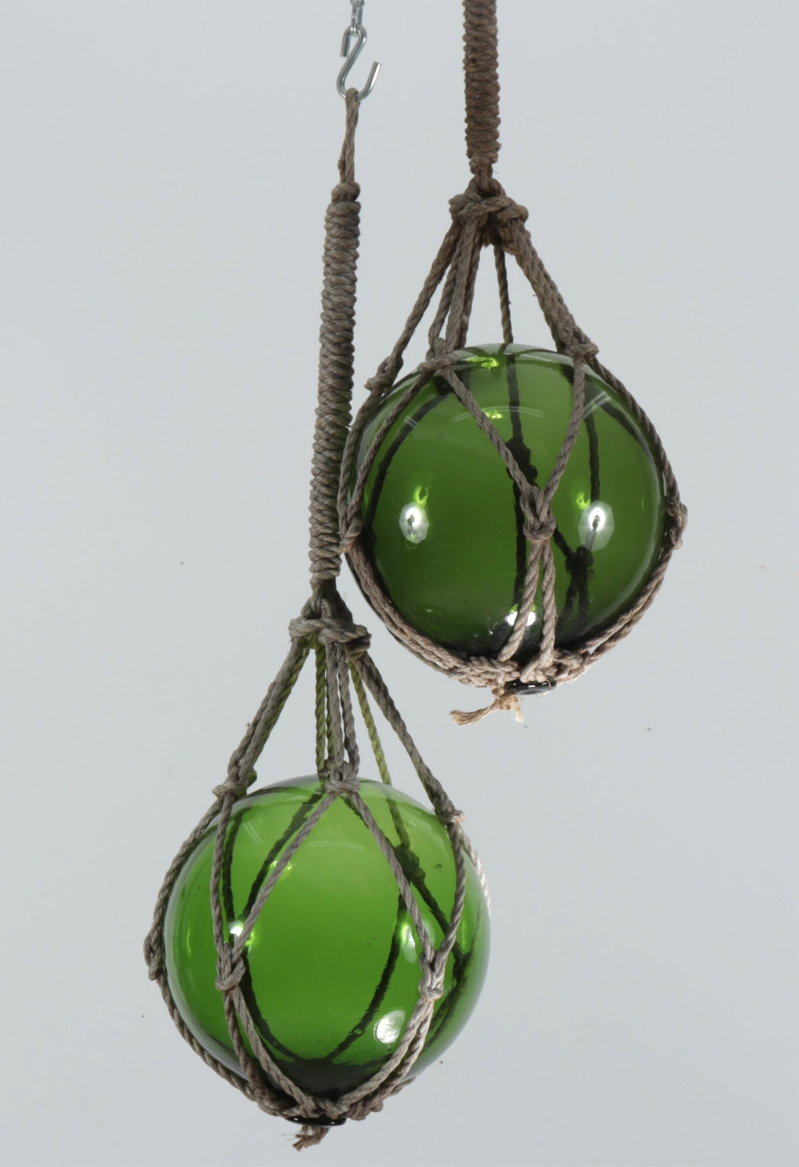 Two Japanese Blown Glass Buoys: Two vintage Japanese blown green glass netted buoy floats.