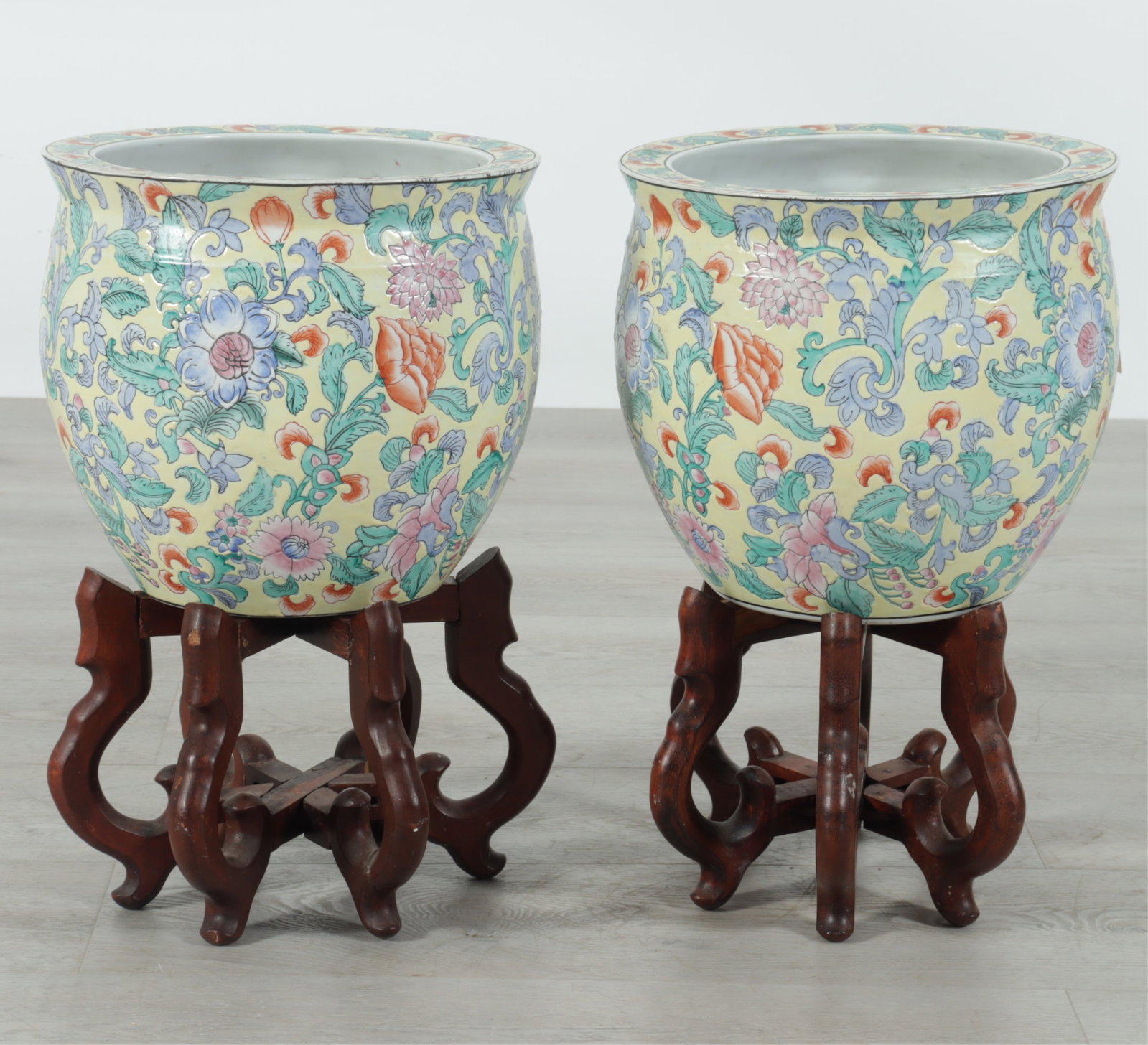 Pair Chinese Porcelain Fish Bowls on Stands: A pair of small Chinese yellow ground Famille Rose porcelain fish bowls on hardwood stands. Each marked on bottoms.