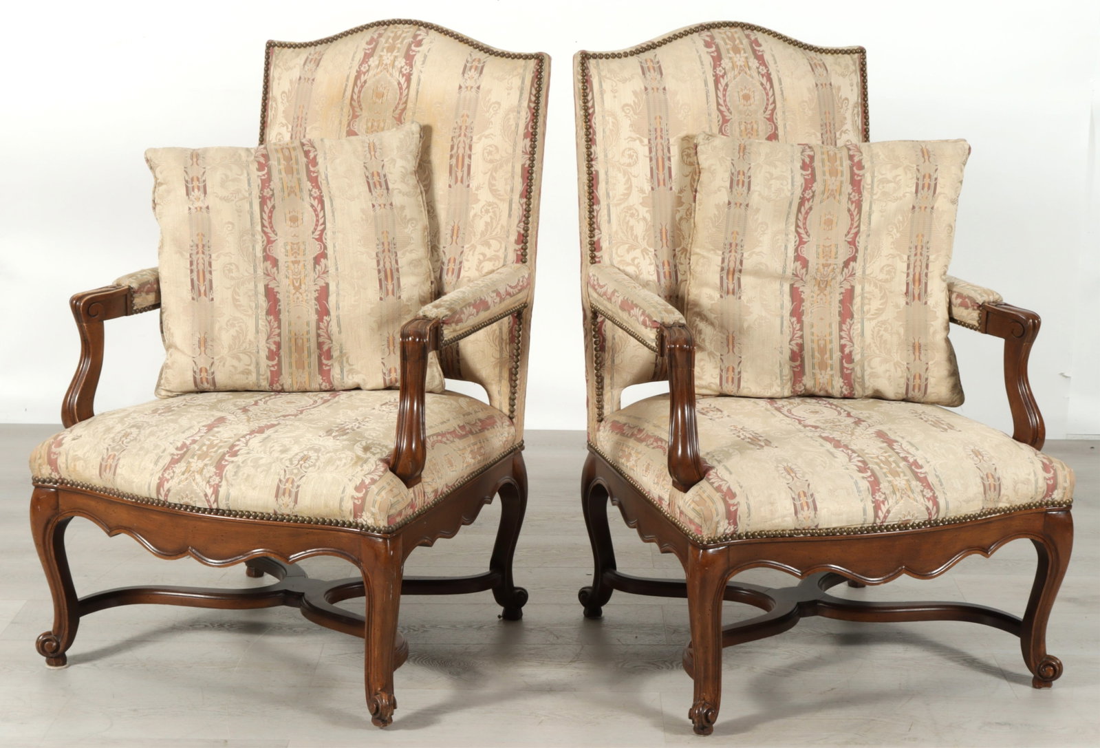 Pair Heritage French Provincial Style Fauteuil: Pair of Heritage Furniture French provincial style fauteuil, arched crest, upholstered in a striped fabric with damask pattern with two toss pillows, brass nailhead trim, x-form stretchers.