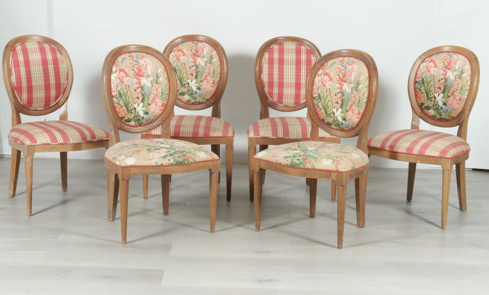 6 Directoire Style Bleached Beech Dining Chairs: A group of six Directoire style bleached beech dining chairs upholstered in a complementary mix of plaid and foliate fabric. Two with all foliate, two with all plaid, and two with a combination.