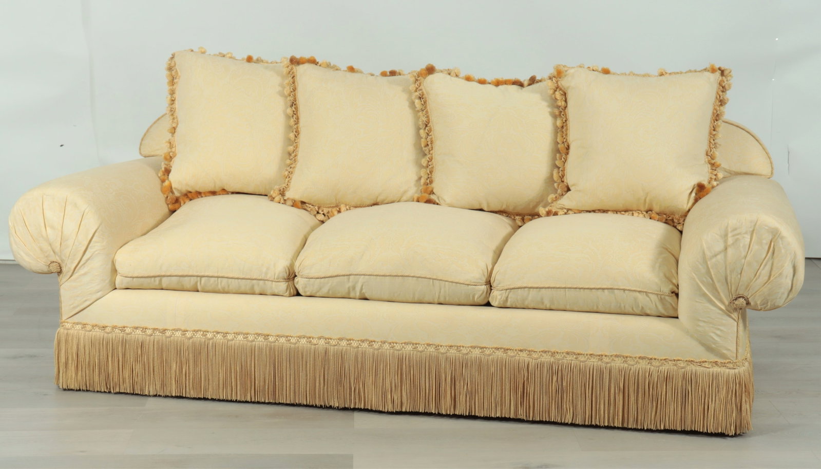 Custom Fortuny Upholstered Sofa: Custom roll arm sofa upholstered in Fortuny cream-yellow foliate batik upholstery with heavy fringe skirt and rolled arms.