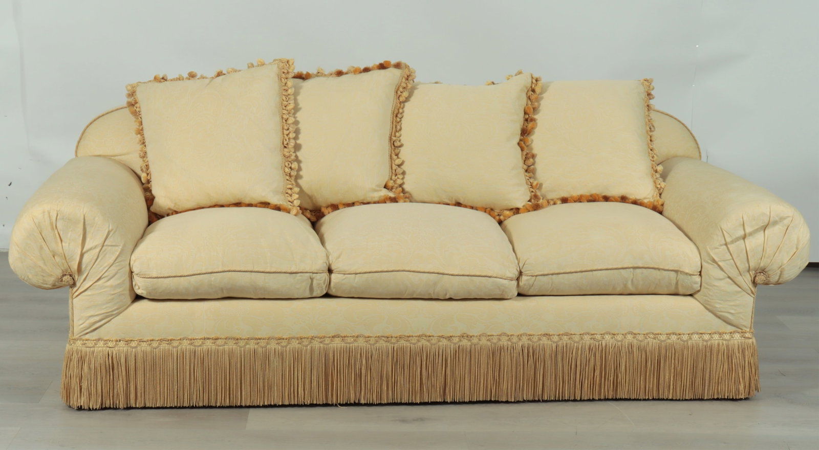 Custom Fortuny Upholstered Sofa: Custom roll arm sofa upholstered in Fortuny cream-yellow foliate batik upholstery with heavy fringe skirt and rolled arms.