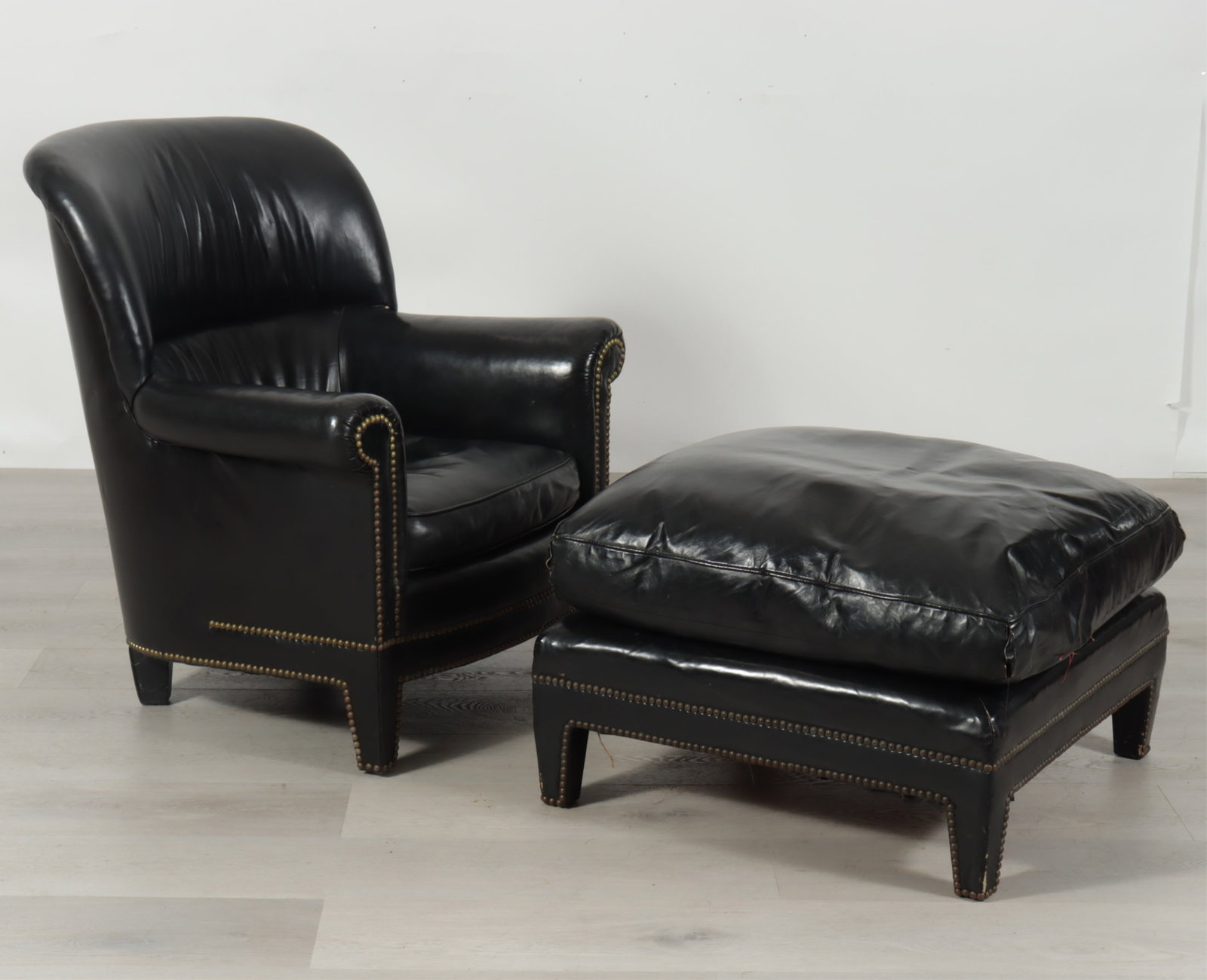English Leather Club Chair & Ottoman: English brass tacked black leather club chair with ottoman. Down filled cushions.