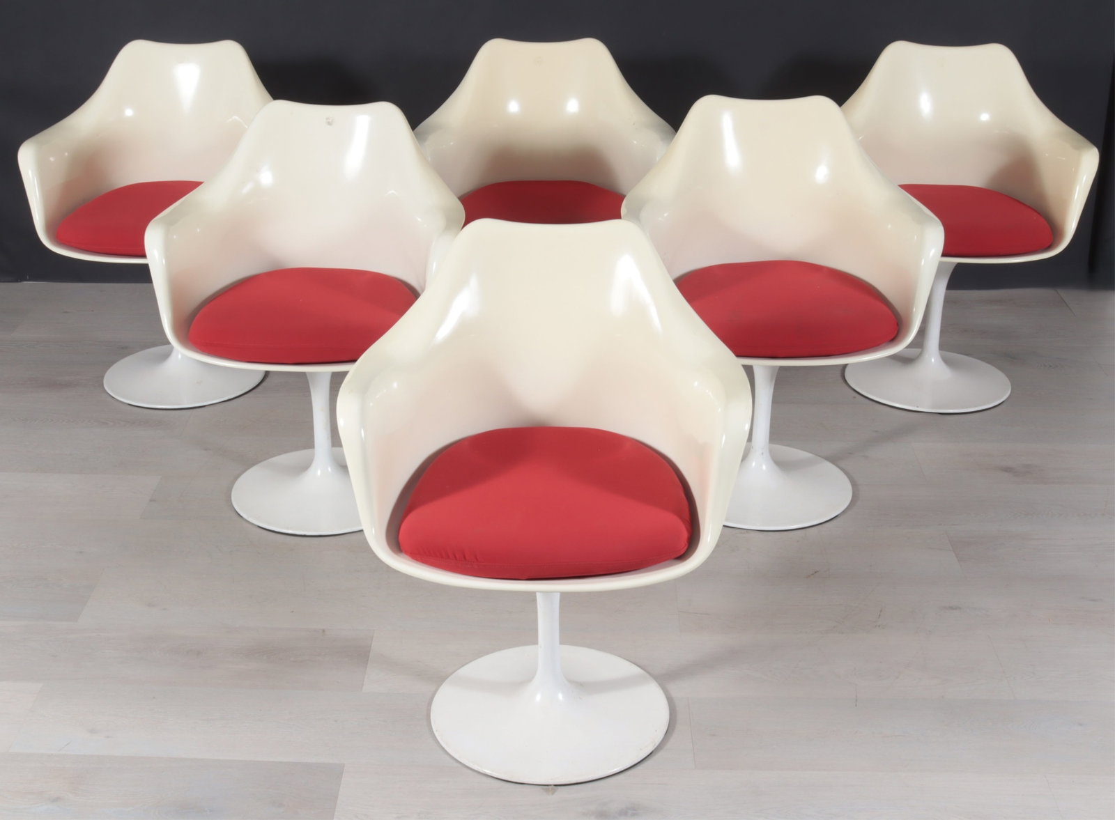 Six Eero Saarinen Style Tulip Armchairs: A group of six Eero Saarinen style "Tulip" fiberglass shell armchairs with red cotton upholstered cushions.
