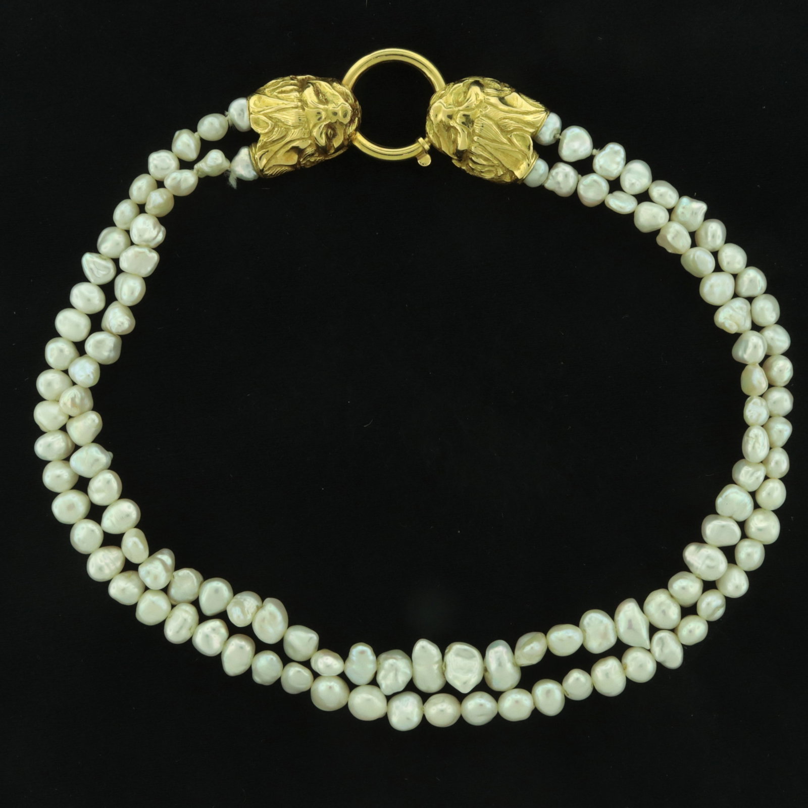 Baroque Pearl Double-Strand Necklace: Baroque pearl double-strand necklace terminating with 18 karat yellow gold double lion head and loop clasp. Unsigned, unmarked, acid tested. 17 1/4" long Property from an Alpine, New Jersey estate.