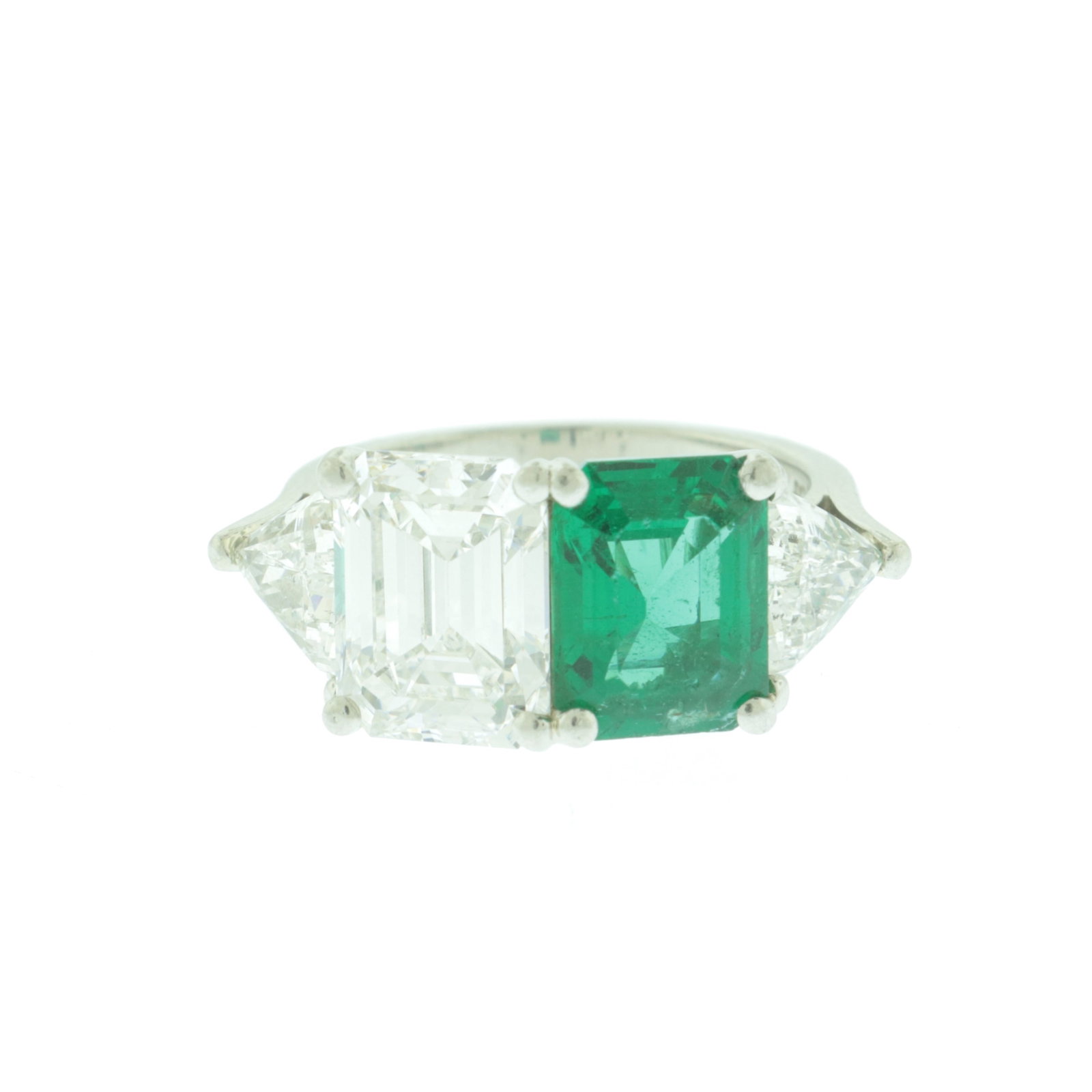Zambian Emerald and Diamond Ring: Containing a 3.30 ct emerald cut diamond, F-G color, VS1-VS2 clarity, flanked by two 1.60 tcw modified triangular brilliant cut diamonds, F-G color, SI1-SI2 clarity. Further containing a 2.60 ct Zambi