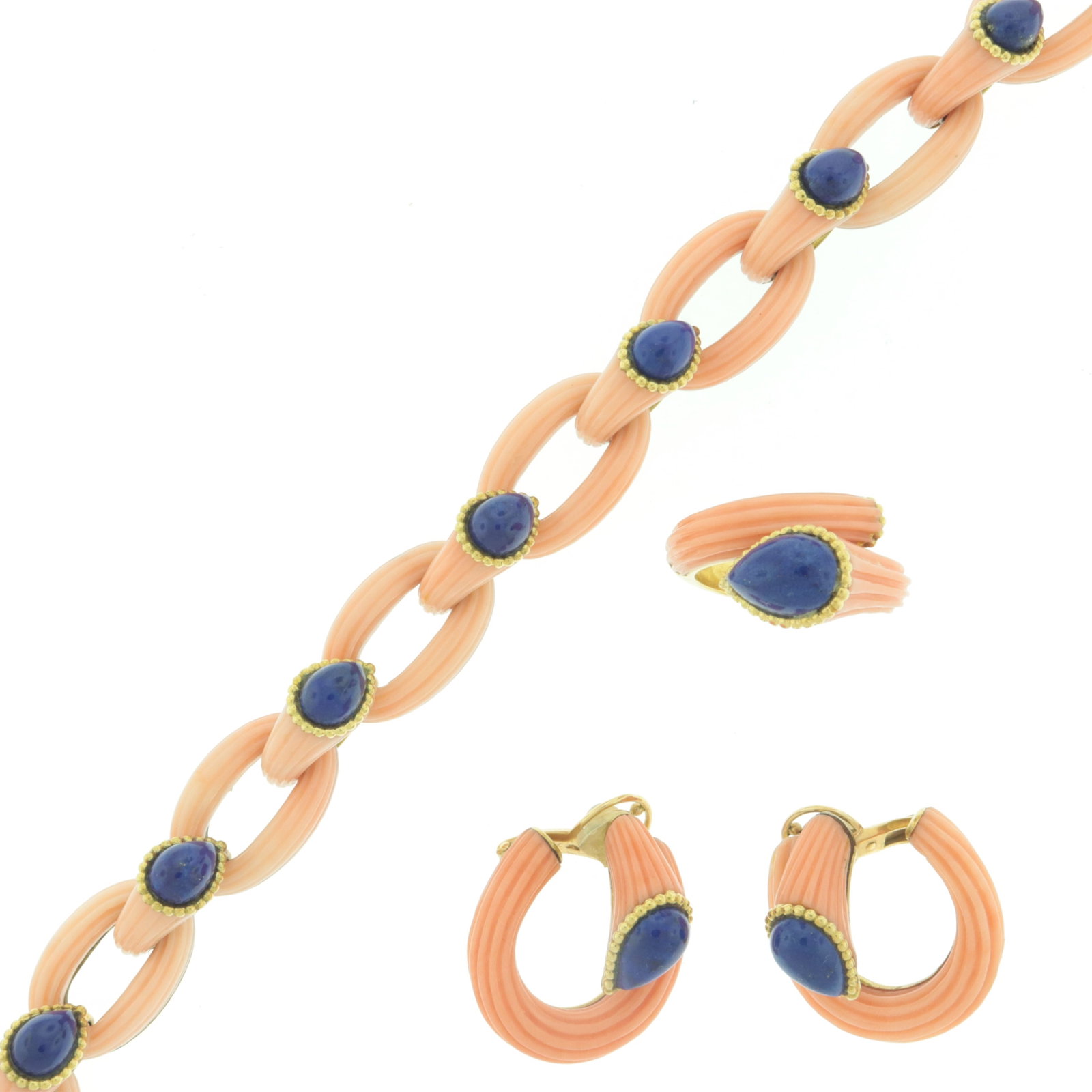 Boucheron Coral and Lapis Parure: Vintage Boucheron three piece parure, comprising a bracelet, ring, and pair of earclips. Reeded carved angel skin coral topped with lapis lazuli tear-drop cabochon, set in 18 karat yellow gold. Each p