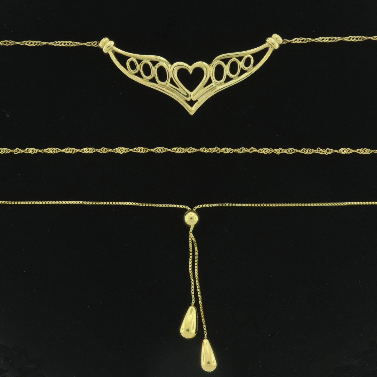 Three 14K Yellow Gold Necklaces: A group of three 14 karat yellow gold necklaces. Comprising: 16" micro box chain with tassels, 18" rope twist with central heart and wings, 19" rope twist. Total of 6.5 grams. 16" to 19" long. Propert