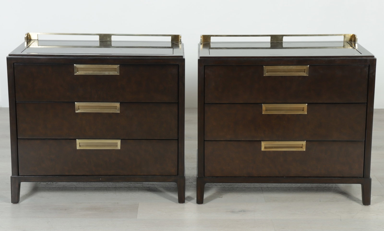 Pair Marge Carson Lake Shore Drive Side Tables: Pair of Marge Carson Lake Shore Drive side tables or nightstands. Brass mounted walnut finish with inset black marble top. Three drawers, top gallery rail. 29.25" H x 31.5" W x 18.75" D