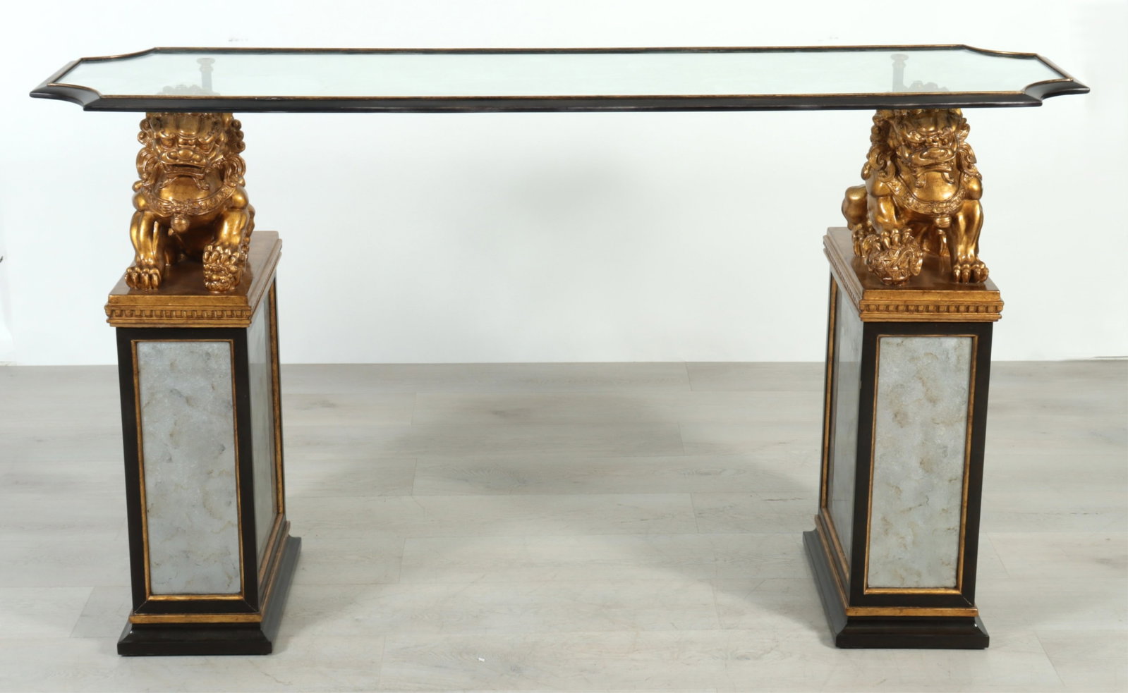 Marge Carson Cross-Channel Console: Marge Carson Cross Channel Console, gilded fu dogs on antiqued mirrored and walnut supports with glass top. 44.5" H