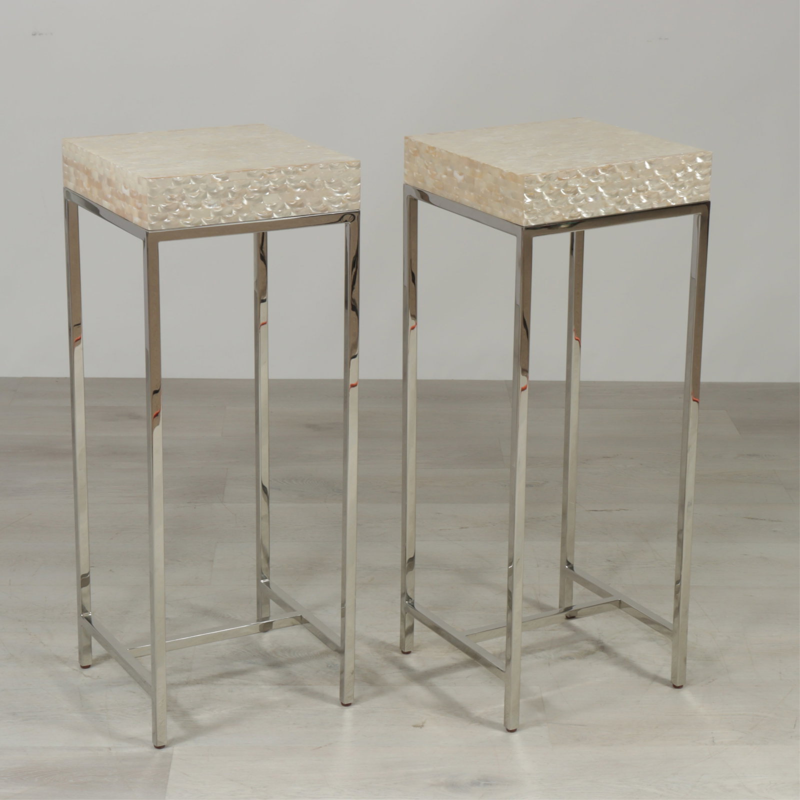 Pair Marge Carson Malibu Pedestals: Pair of Marge Carson Mother Malibu pedestals, chrome base with 'pearl' finish tessellated top. 36.25" H x 14.25" square