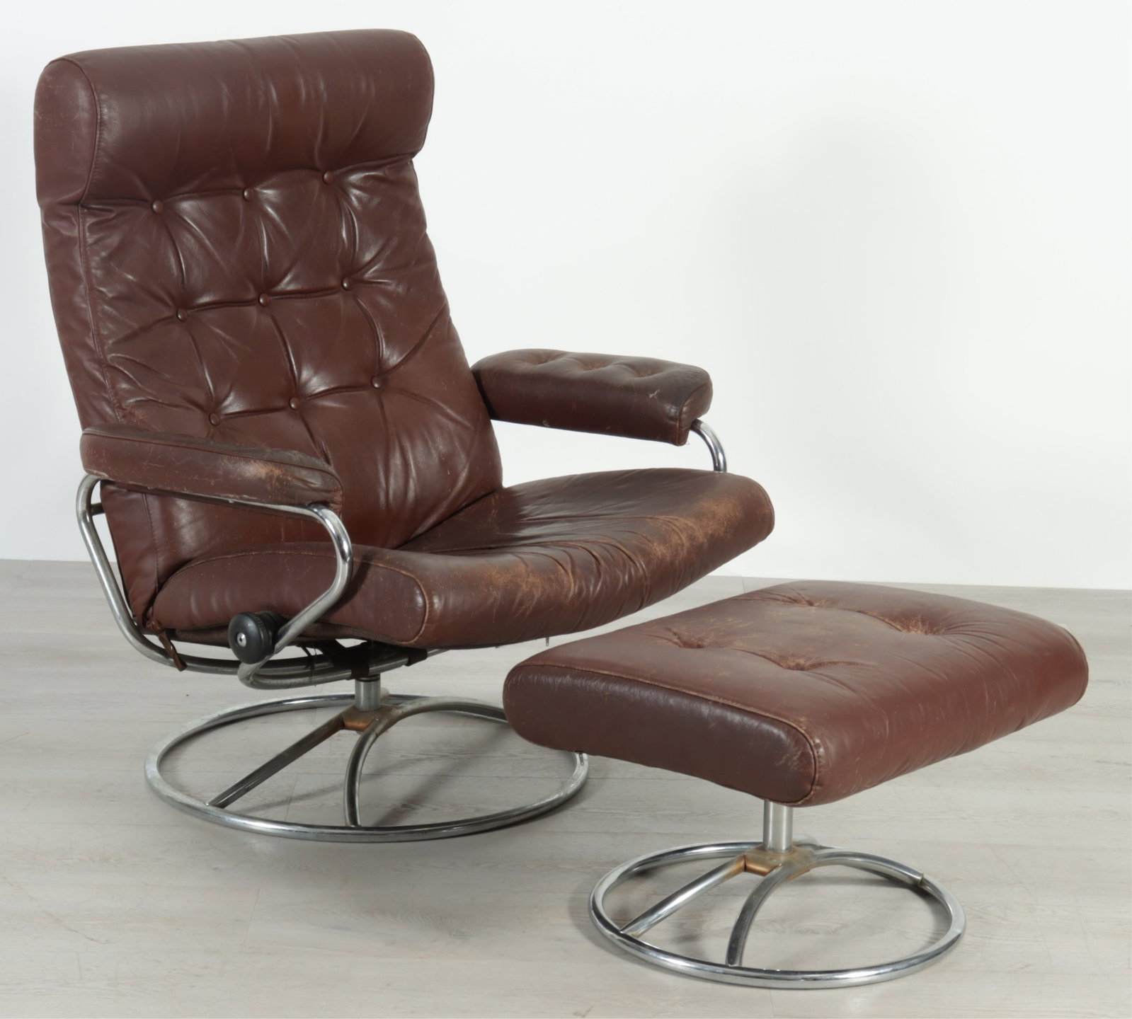 Ekornes Stressless Chrome Armchair & Ottoman: Ekornes Stressless chrome armchair and ottoman, in brown tufted leather upholstery Chair 39" H x 32.5" W x 32" D
