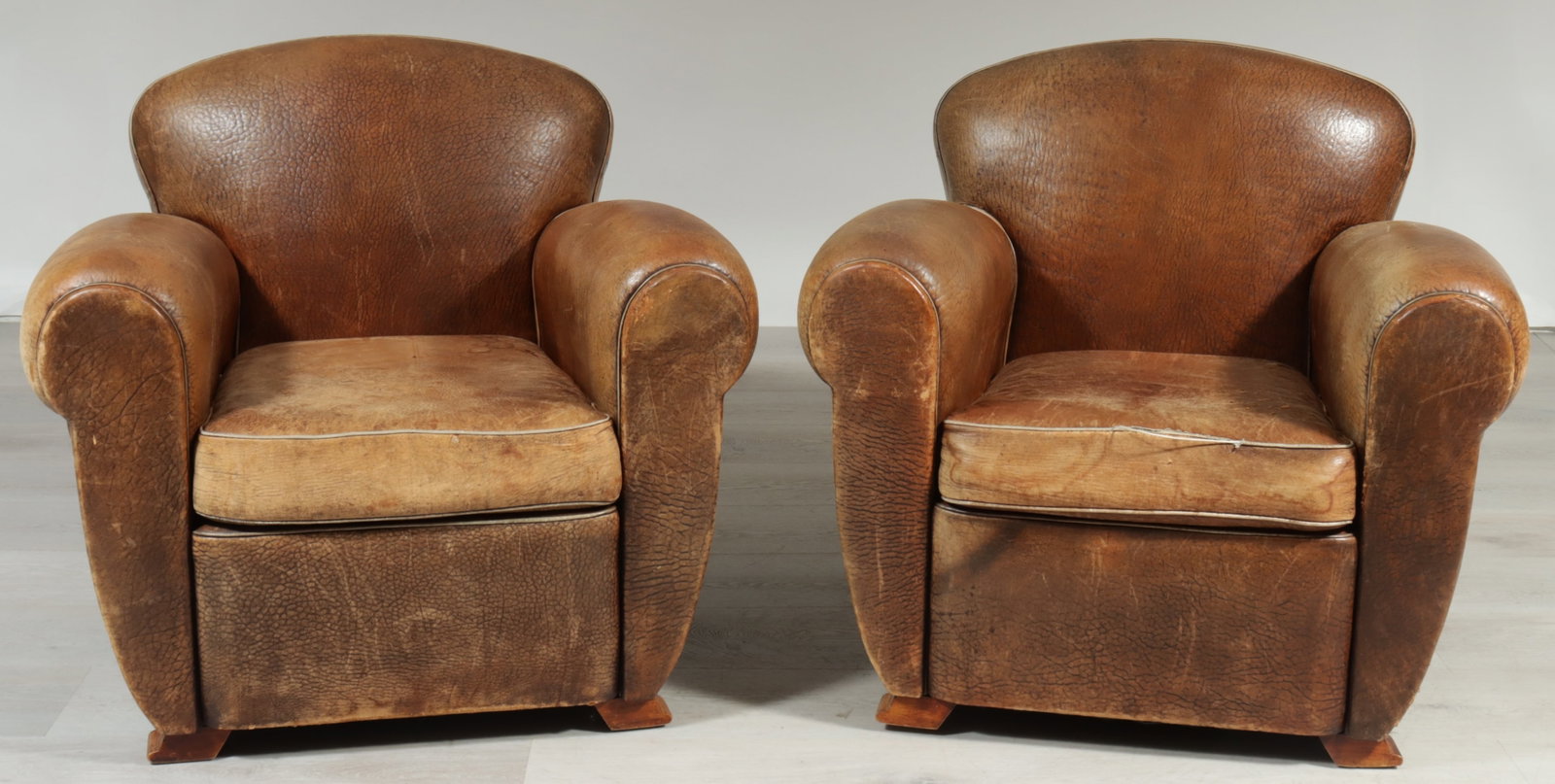 Pair of Posse Leather Club Chairs: Pair of art deco style leather club chairs by Posse Furniture LA, upholstered in brown leather. 31" H x 34" W x 36" D