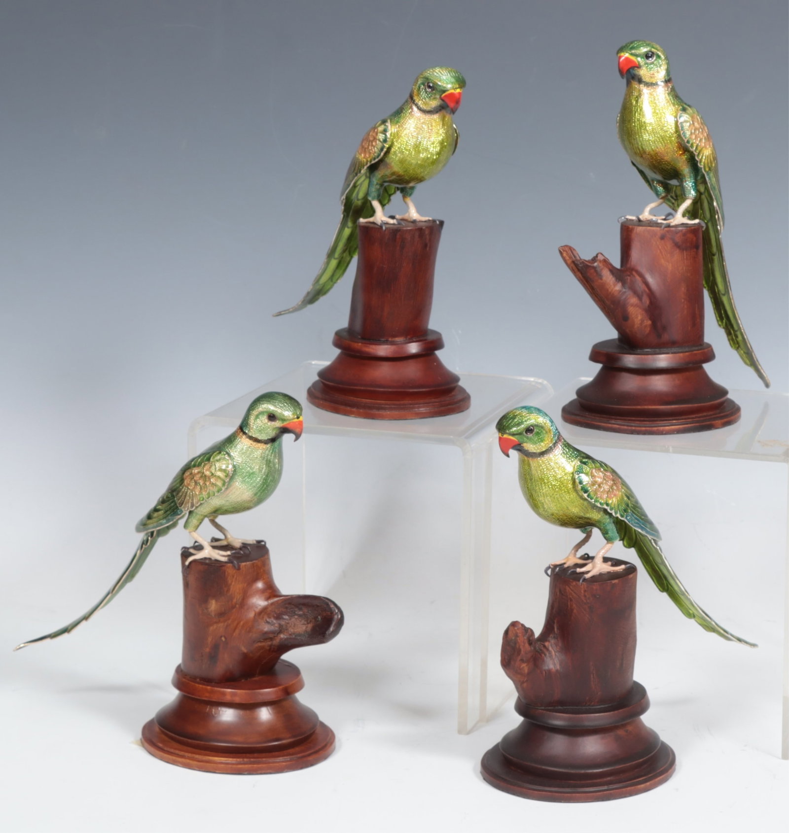 Four Indian Enameled Copper Parrots: A group of four Indian enameled copper parrots on wooden stands. 7.25" H