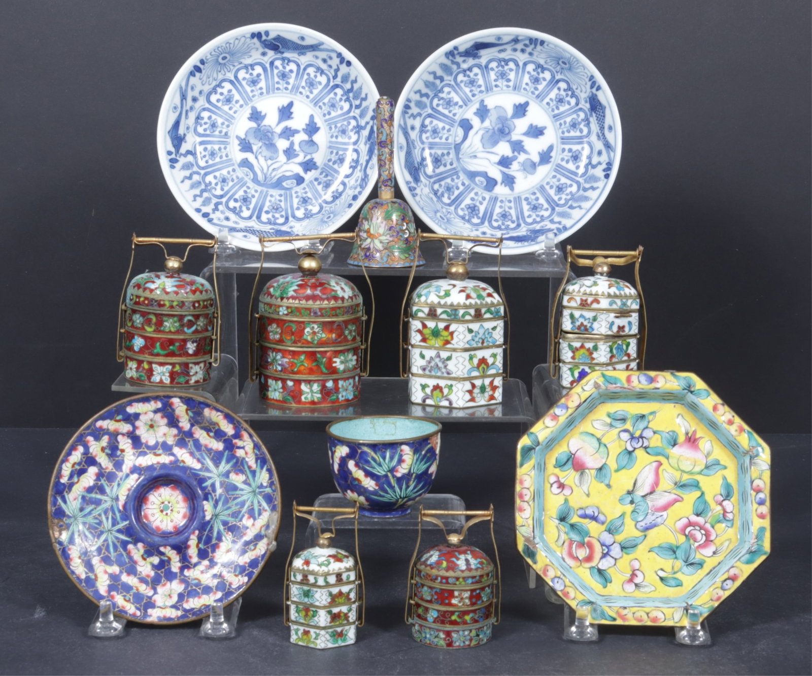Asian Porcelain & Metal Tablop Objects: Group of Asian porcelains and metal wares, includes two sets of cloisonne enamel and brass tiffin boxes, a bell, an octagonal plate with yellow and blue floral, a blue floral cup and saucer along with
