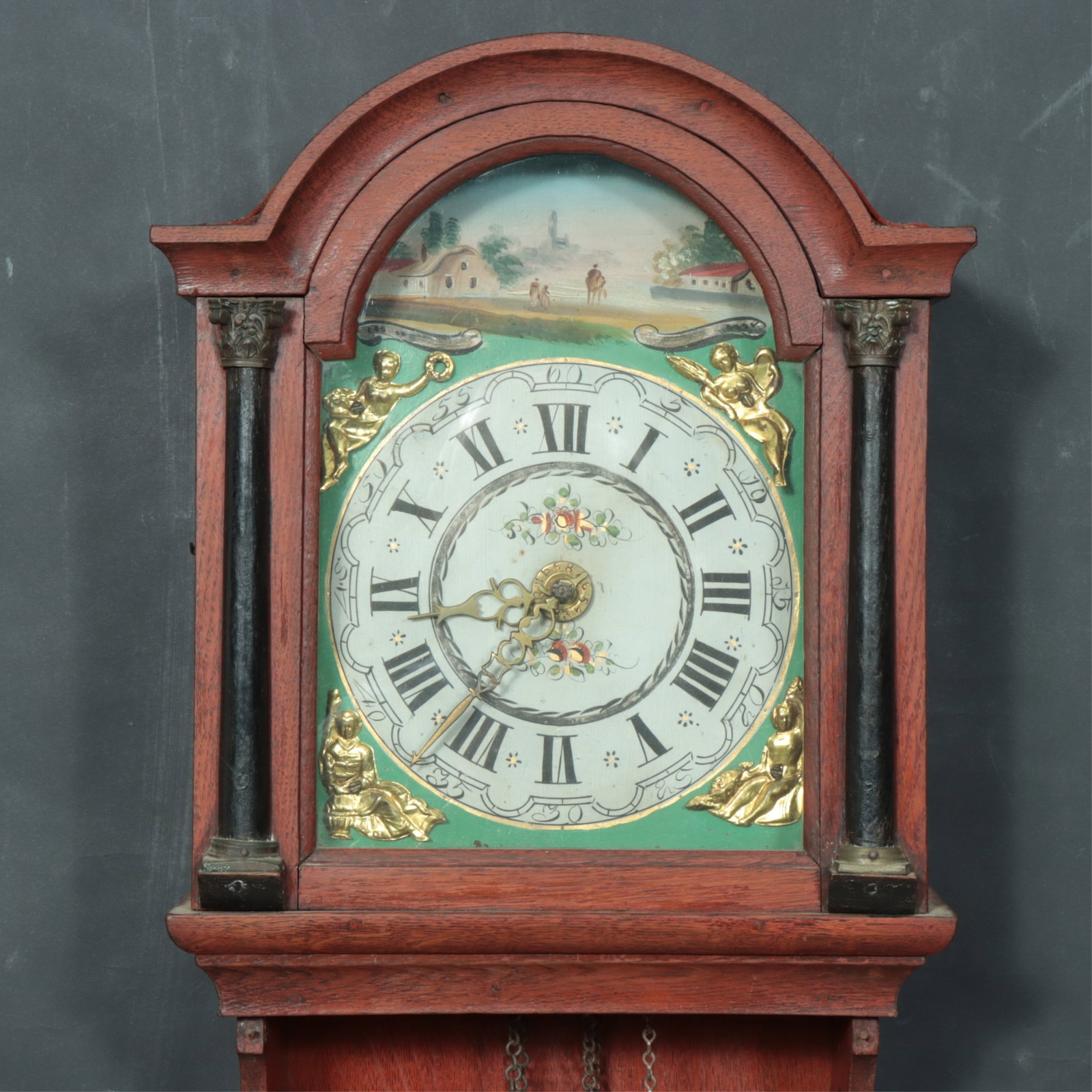 19th C. Friesland Mahogany Wall Clock: 19th C. Friesland (Holland) Wall Clock, c.1840, moulded hood, flanking columns, clock face with gold toned metal figural mounts, painted landscape scene, floral painted face within dials, pressed
