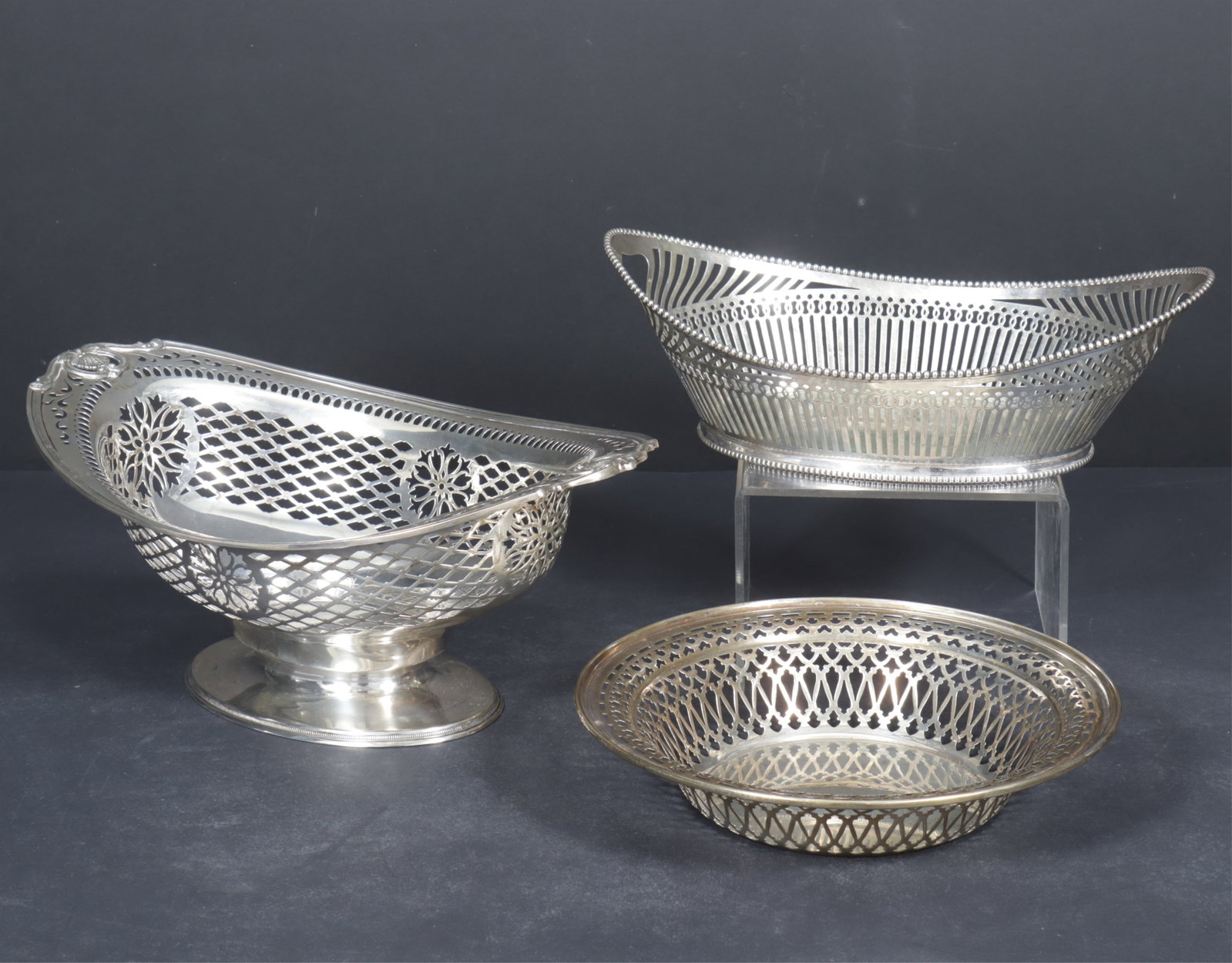 Gorham & Others Sterling Silver Bowl, Baskets: Three sterling silver reticulated serving bowls comprised of a round Meriden Brittania numbered 992; an oval Dutch. 835 Sterling silver reticulated handle basket initialed KB with crown, c.1922; a