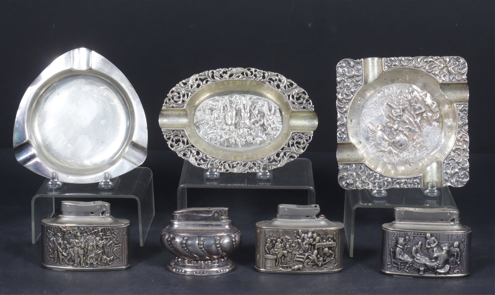 Dutch Sterling Silver Lighters and Ashtrays: Lot of three sterling silver ashtrays and four lighters includes a Dutch repousse ashtray with Tavern Scene, .835, c. 2002; repousse Bar scene, .835; Modernist .800 ashtray, likely Belgian, c.1960, th