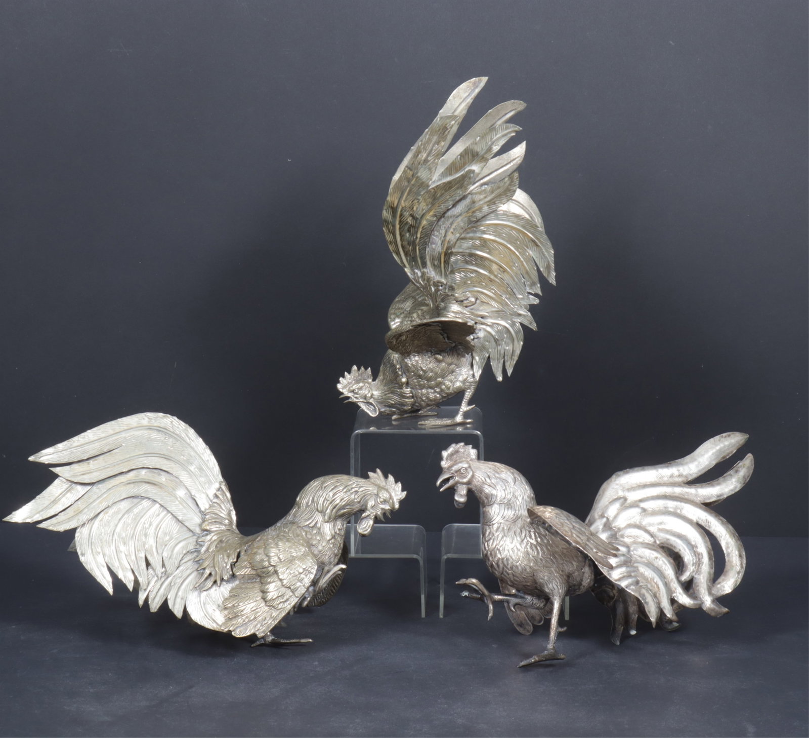 Sterling and Silver Plated Fighting Cocks: One Peruvian sterling silver and two Italian silver plate cast fighting cockerels, 20th C., two silver plated are marked Italy on feather; one (hollow body) marked sterling Peru .825 on verso of