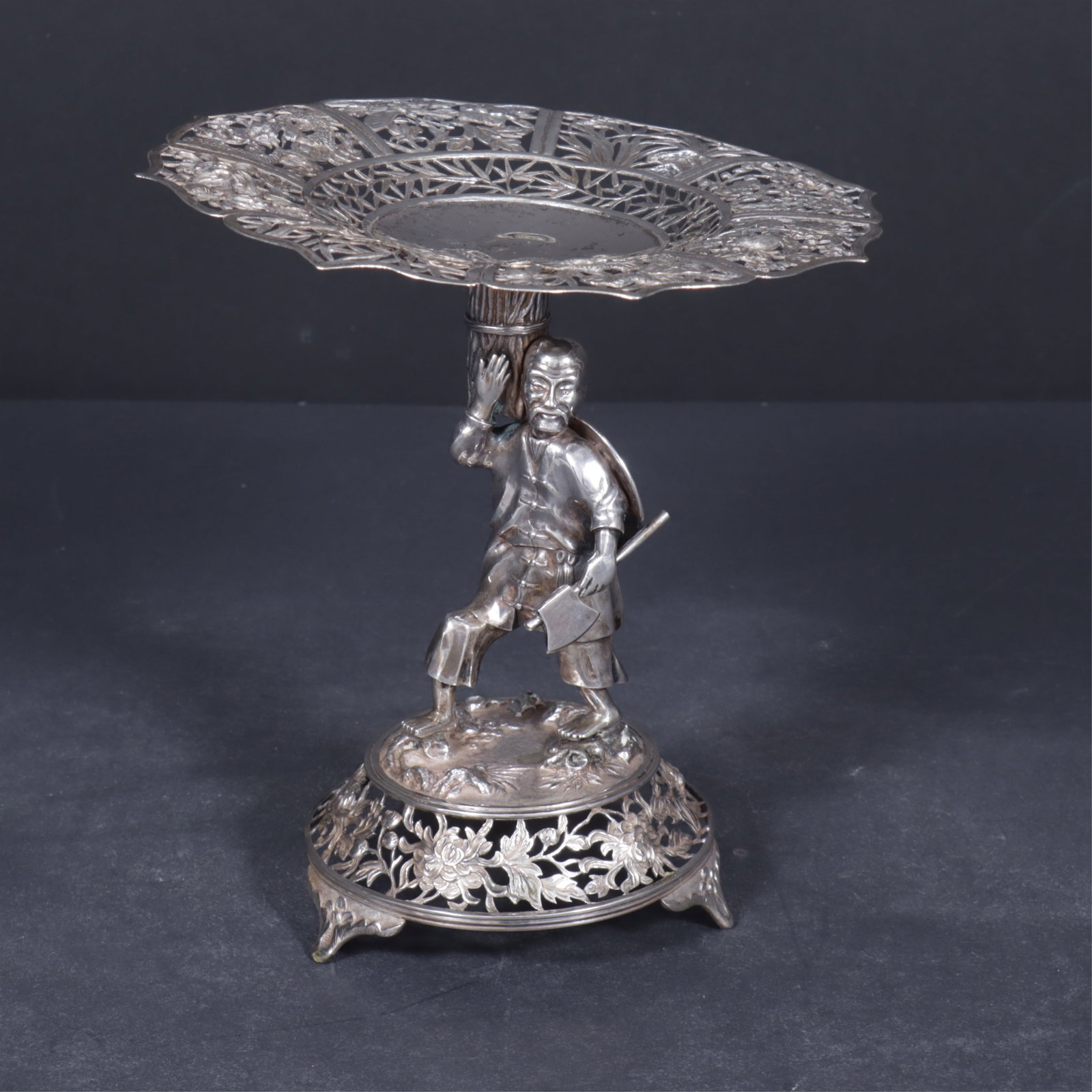 Chinese Sterling Silver Export Chinoiserie Tazza: Mid-Late 19th C. Chinese export sterling silver chinoiserie tazza, marked KC (Retailer Khe Cheong) 90, reticulated chrysanthemum foliate border, figure standing with basket, reticulated circular base