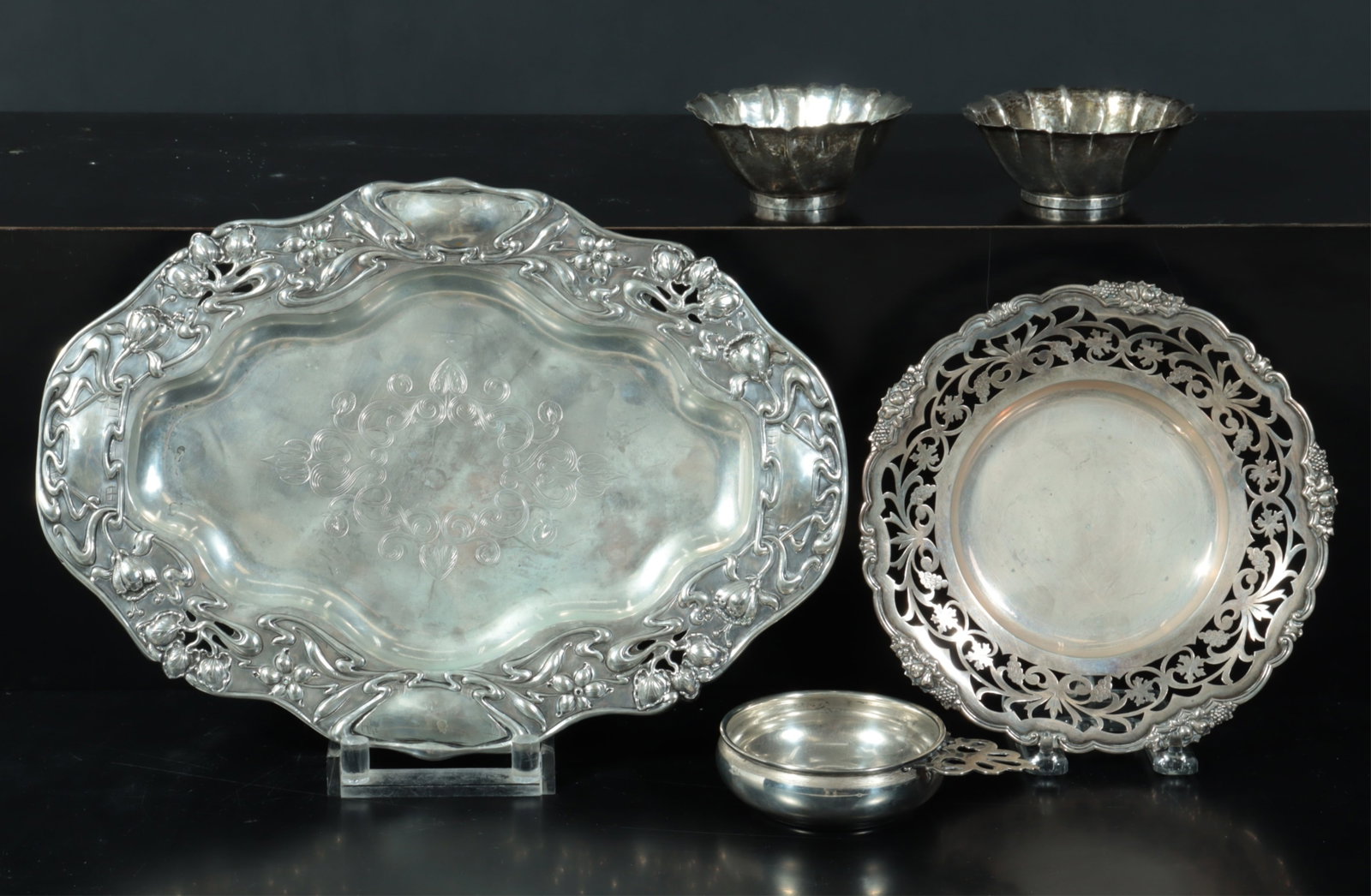Group of .800 Silver Tableware: A group of 20th century .800 silver tableware. Comprising: oval tray with floral repousse (unmarked), Austrian pierced floral plate (toucan assay mark), pair of Austrian petal shaped bowls (toucan