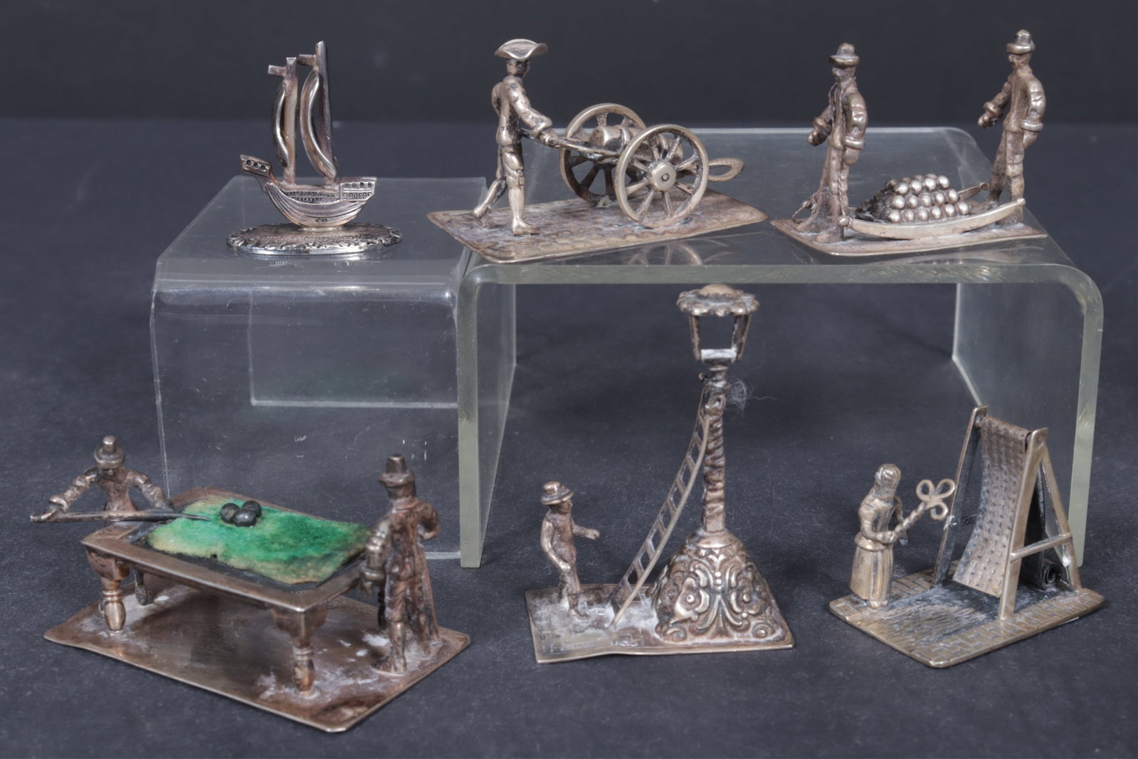Six Dutch Sterling Silver Miniatures: Six Dutch sterling silver miniatures, includes a woman tending to rug, figure with street lamppost, two men playing pool, a man pushing cart with barrel, two sailors carrying cannons, all marked,
