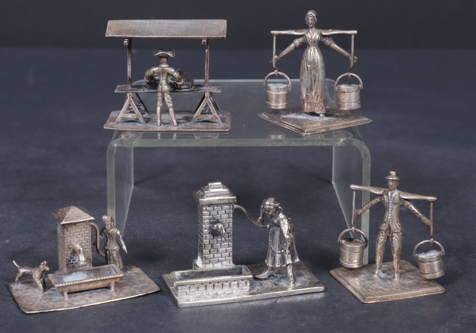 Dutch & Italian Sterling Silver Miniature Figures: Group of Dutch and Italian sterling silver miniatures, includes a Holland marked woman at well with dog, man selling fabric; a man and woman carrying water pails marked D.H., a woman pumping a well,