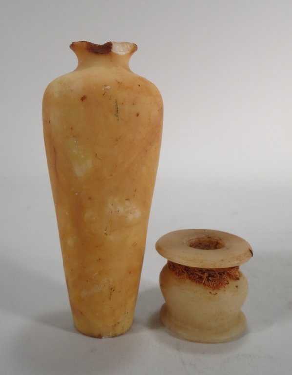 Two Ancient Egyptian Alabaster Cosmetic Vessels: Two ancient Egyptian alabaster cosmetic vessels, New Kingdom, 18th Dynasty, an unguentarium and a kohl jar; the jar with remains of kohl and linen wrapping. (PFUN8200/2)(PFUN8200/2) Measurements: Ingu