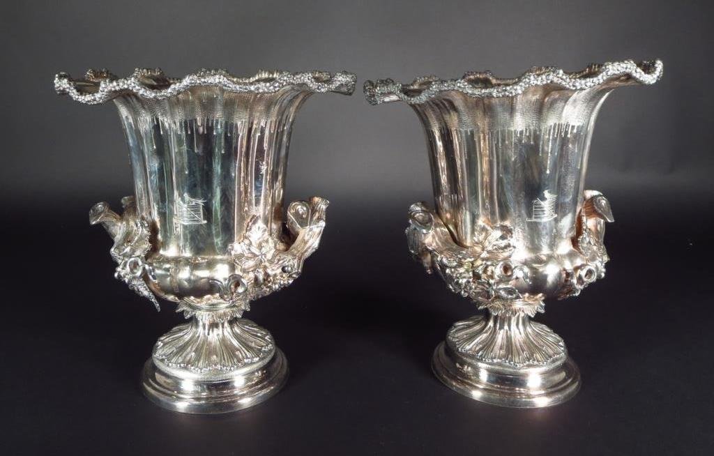 Pair of Silverplated Wine Coolers American: Pr of silverplated wine coolers American by Elkington, 1899, applied grapevine handles. engraved with bird on gate.(NSHA8015) Measurements: 103/4"H Condition: Light wear and tear. Plate loss to liners