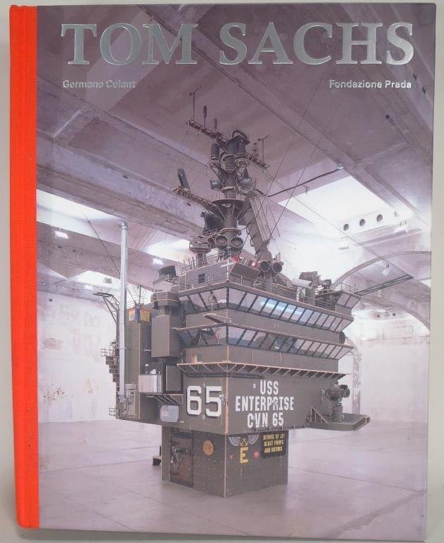 Artist Signed Book, Tom Sachs, Am.: Artist signed book, Tom Sachs, American, born 1966. Catalogue to accompany 2006 exhibition in Milan, Italy. "Germano Celant, Fondazione Prada"(SBAR2302) {PR} Measurements: 12.25" x 9.75" Condition: Sc