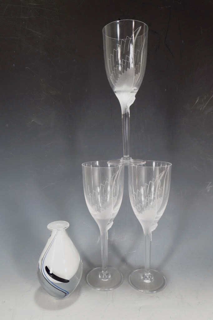 Lot of Three Signed Lalique Wine Glasses, French: Lot of 3 signed Lalique wine glasses, French, 20th century. Matching glasses with angel design. Also a signed Kosta vase. (4 pcs)(GERS2302/4) {PR} Measurements: 8" high Condition: 1 has chipped base, 