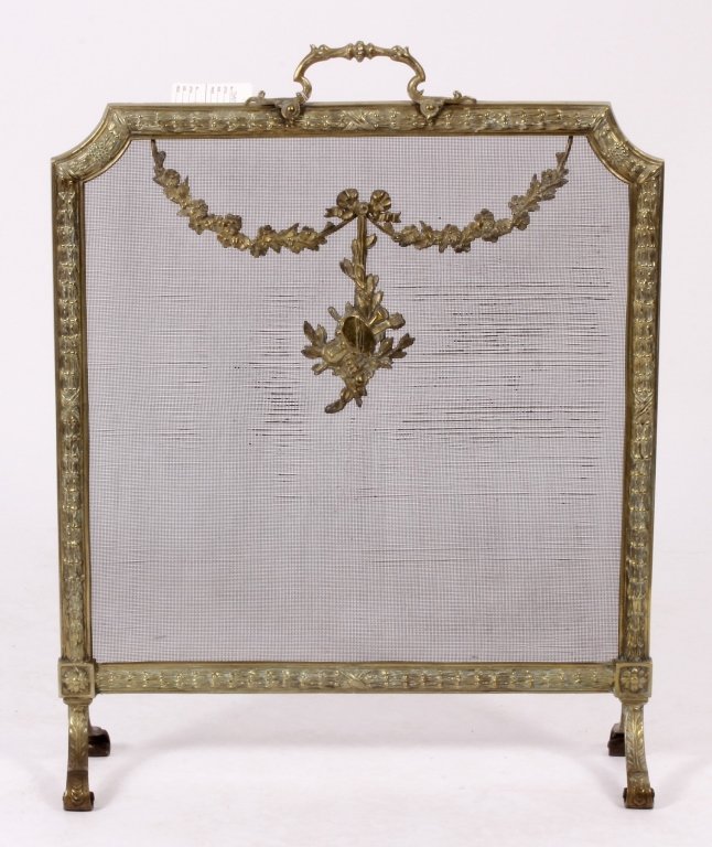 Louis XVI Style Brass and Mesh Fire Screen, E 20 C: Louis XVI Style Brass and Mesh Fire Screen, Early 20th C., with leaf and berry border, mesh screen, with brass musical trophy in center, scrolled feet; the back stamped M.S. 47(JGAR7829)(TBK) Measurem