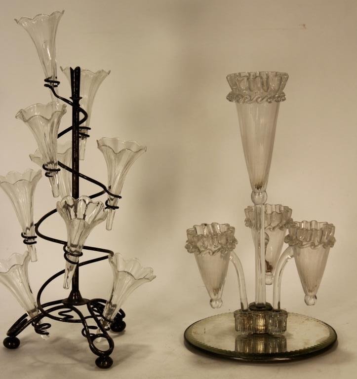 Two French Glass Epergnes, c. 1900: Two Glass Epergnes, French, c. 1900; one a Belle Epoque example on a silver plate scrolling stand wind 9 vases, the other with a central vase and 3 side vases on a mirrored base.(DJOD7219/2)(WK) Measu